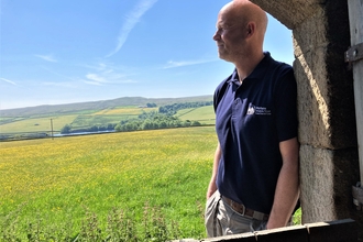 Mark Dinning pictured through barn door looking out over Hannah's Meadow
